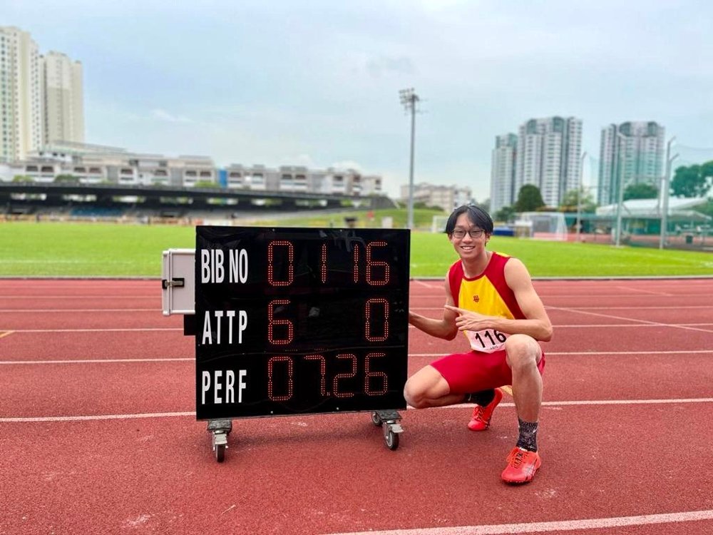 Abel crouching beside a scoreboard showing a 7.26m long jump